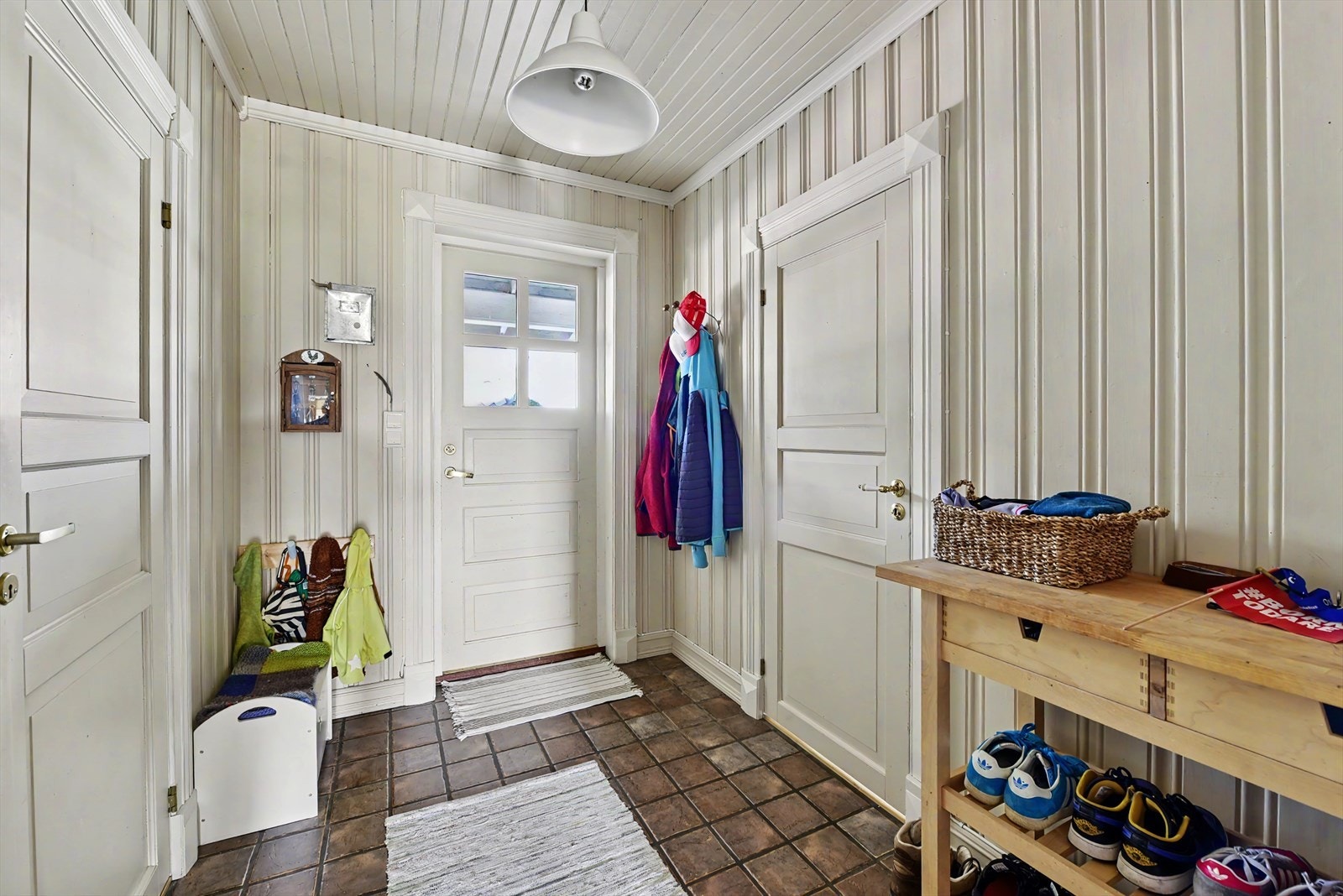 Romslig entré med panel på veggene og god plass til oppbevaring av yttertøy og sko. Galleribilde