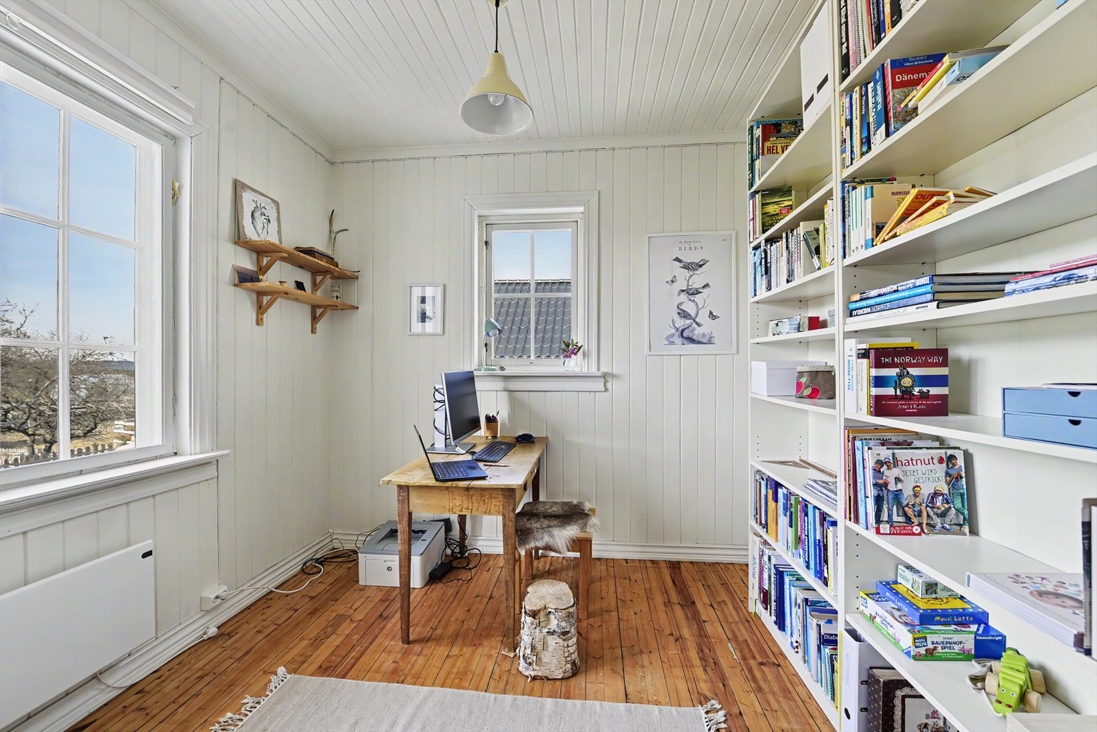 Fleksibelt rom i første etasje, i dag brukt som kontor, med store vinduer og tregulv. Galleribilde