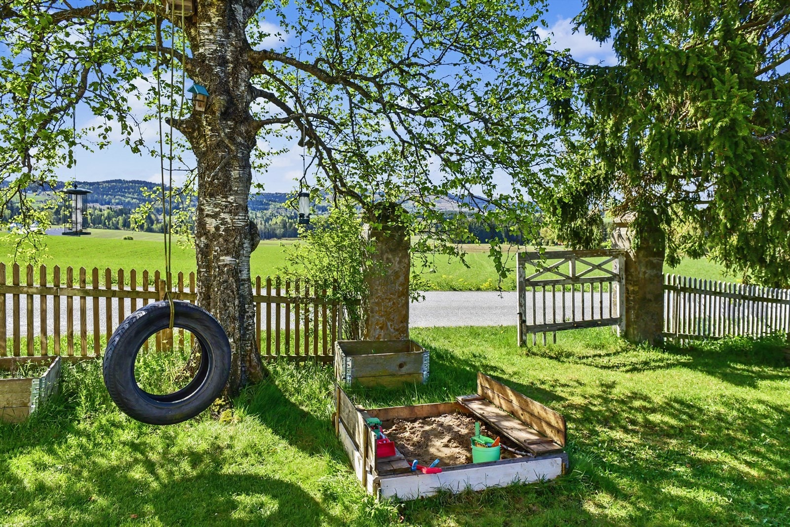 Sandkasse og husker gjør hagen til et flott sted for barn. Galleribilde
