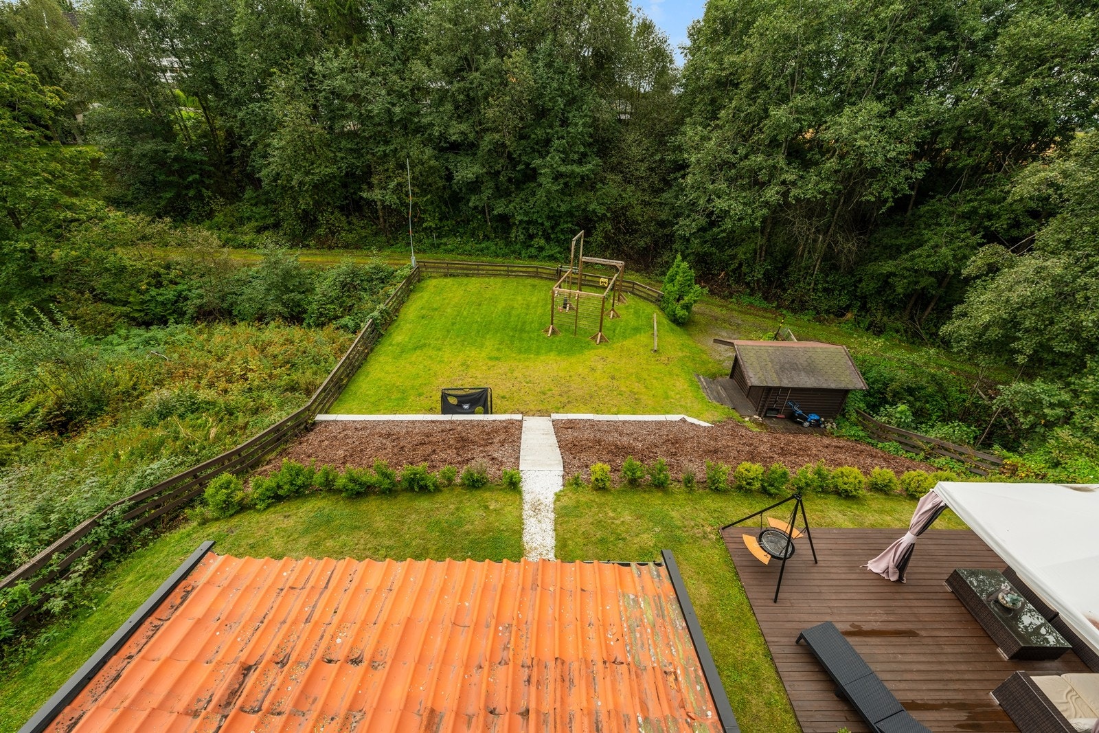 Utsikt fra boligen ned mot hagen og uteplassen. Galleribilde