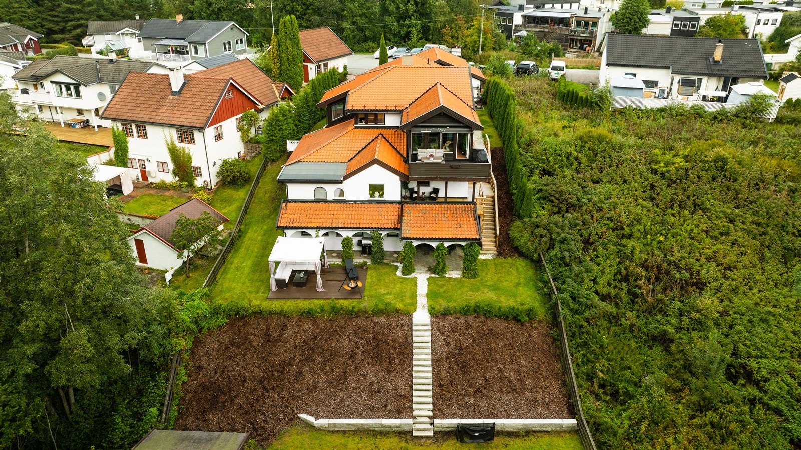 Eiendommen ligger i et skrånende terreng, med en opparbeidet og terrassert hage. Galleribilde