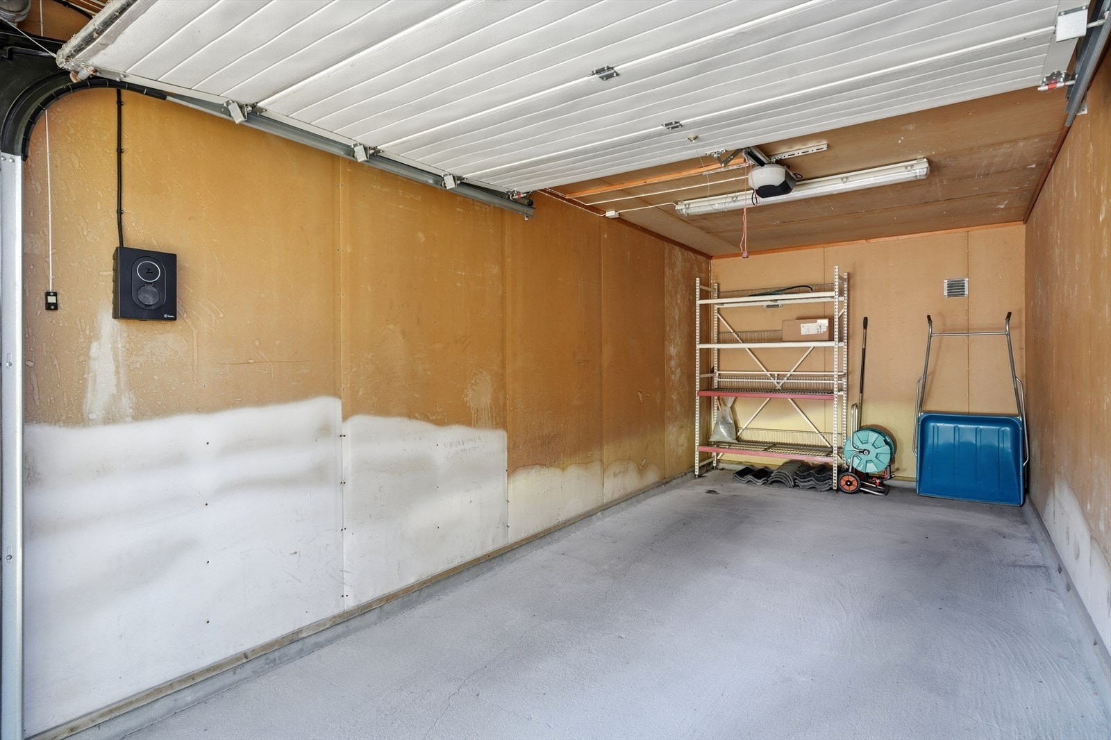 Tilhørende garasje på 17 m² med god plass til bil og oppbevaring. Elbillader er montert på vegg, fra Zaptec. Galleribilde