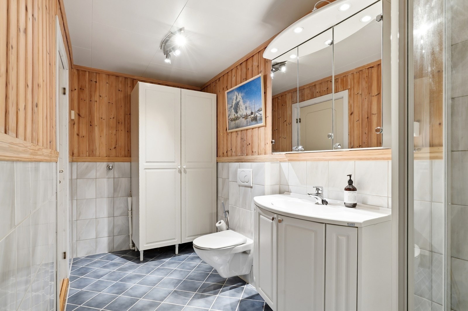 Badet i underetasjen har flislagt gulv med varmekabler og opplegg for vaskemaskin. Galleribilde