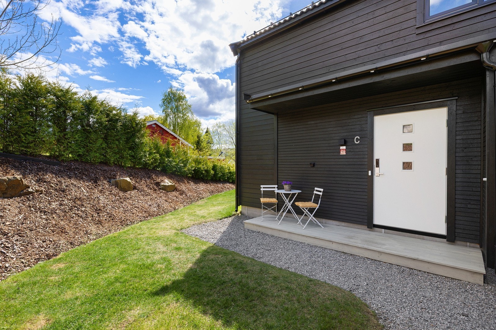 Boligen har gruslagt gårdsplass, med tilgang til hagen. Galleribilde