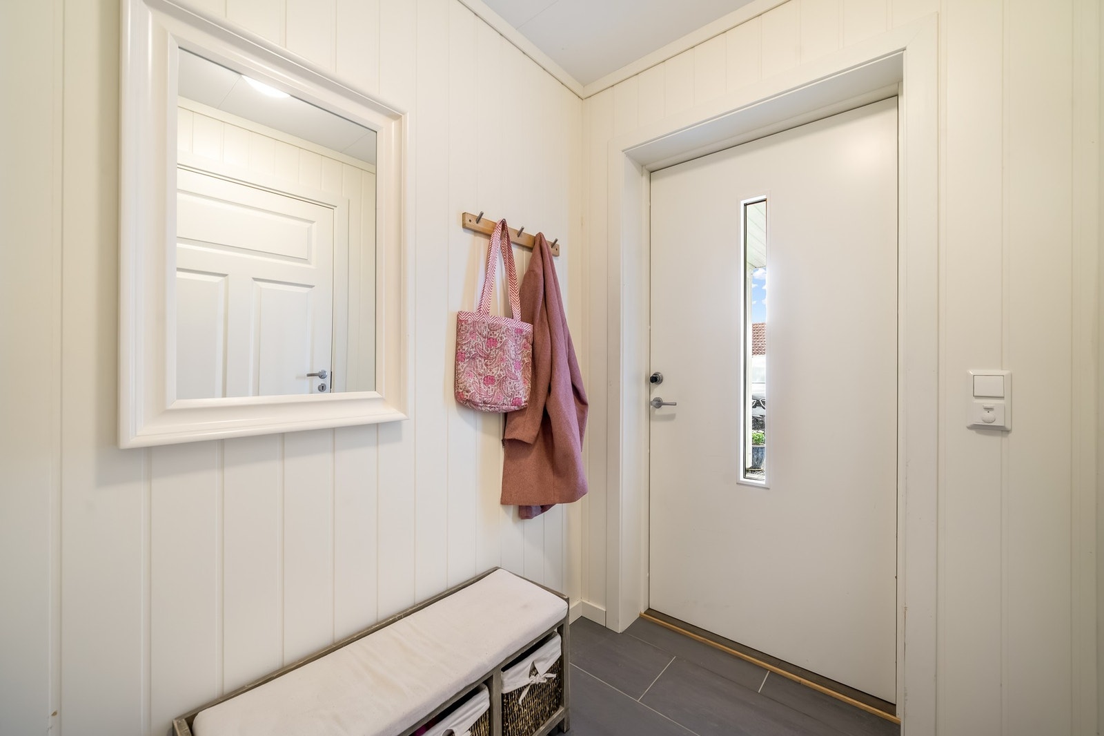 Inngangspartiet leder videre inn til en praktisk, flislagt entrè hvor man han henge fra seg yttertøyet. Innenfor entrè er en stor hall med laminatgulv og varmekabler. Lyse rom med mdf-plater på vegg og takess i himling. Galleribilde