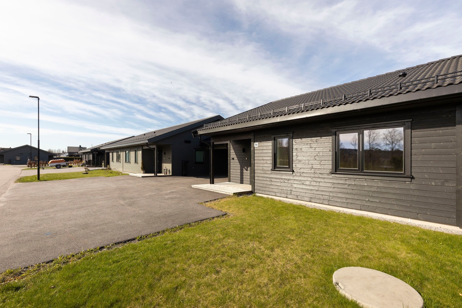 Asfaltert gårdsplass og parkering i carport Galleribilde