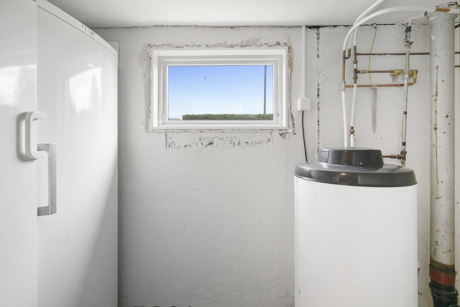 Vaskerommet har betonggulv og opplegg for vaskemaskin og tørketrommel. Galleribilde