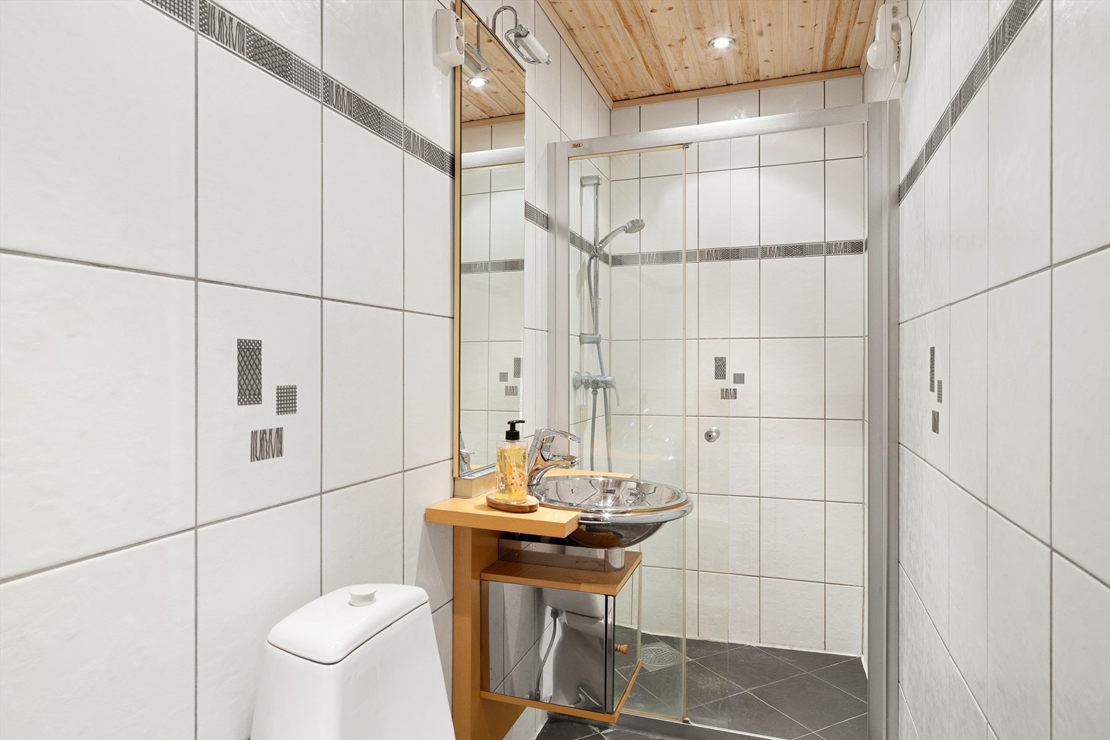 Badet i første etasje er helfliset med varmekabler og innredet med toalett, servant og dusjhjørne. Galleribilde