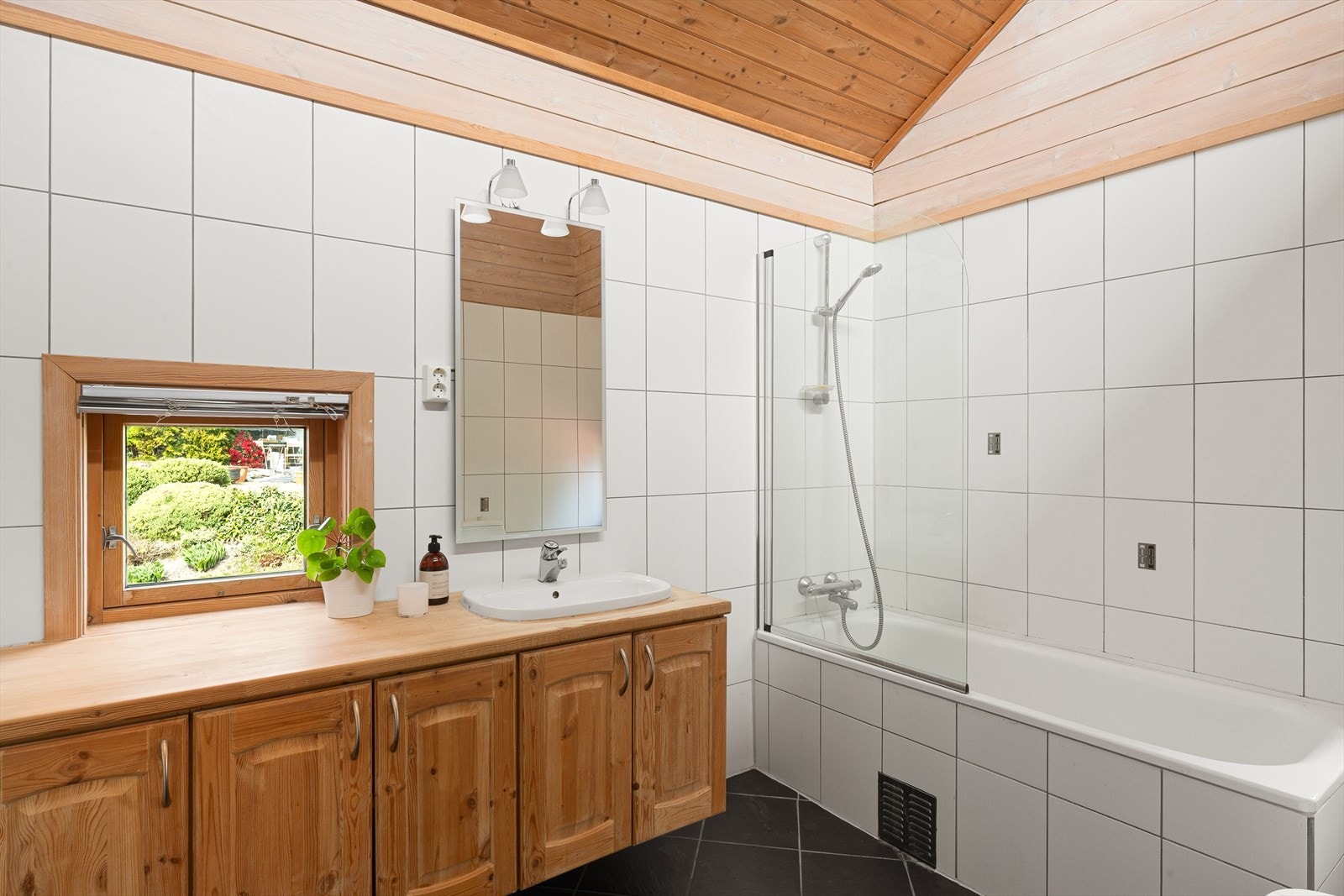 Badet er helfliset med varmekabler i gulvet og innredet med badekar, servant, bidé og toalett. Galleribilde
