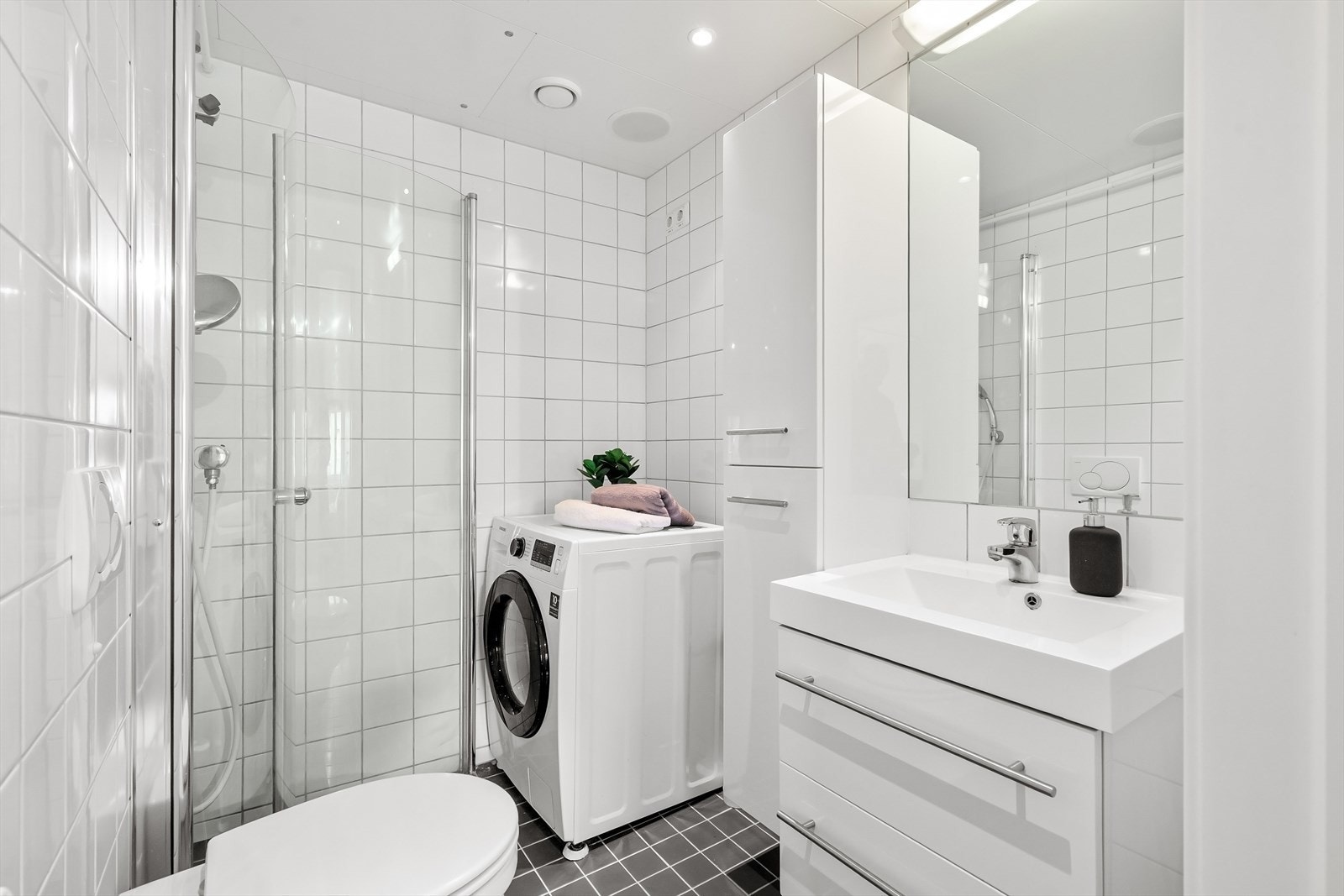 Pent, flislagt bad med opplegg for vaskemaskin. Galleribilde