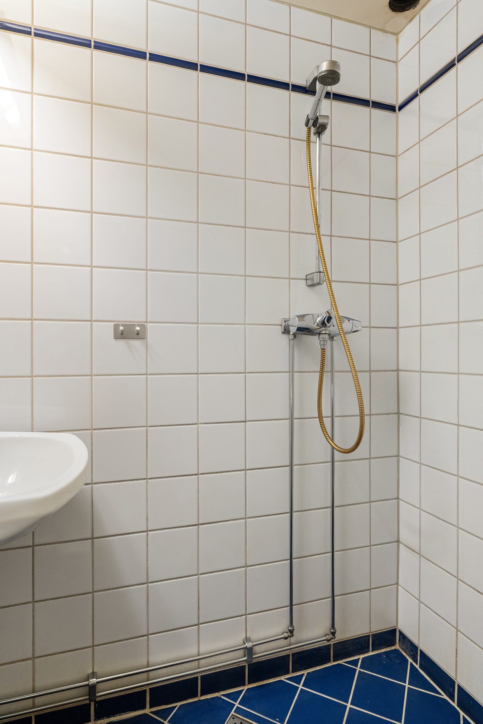Baderommet er utstyrt med vegghengt servant med speil og belysning over, vegghengt dusj og gulvstående toalett. Galleribilde