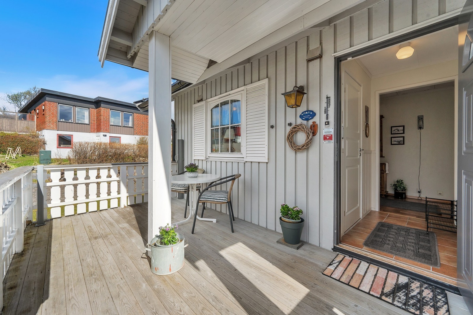 Overbygget inngangsparti med terrassebord i impregnerte materialer. Foto: H5 Galleribilde