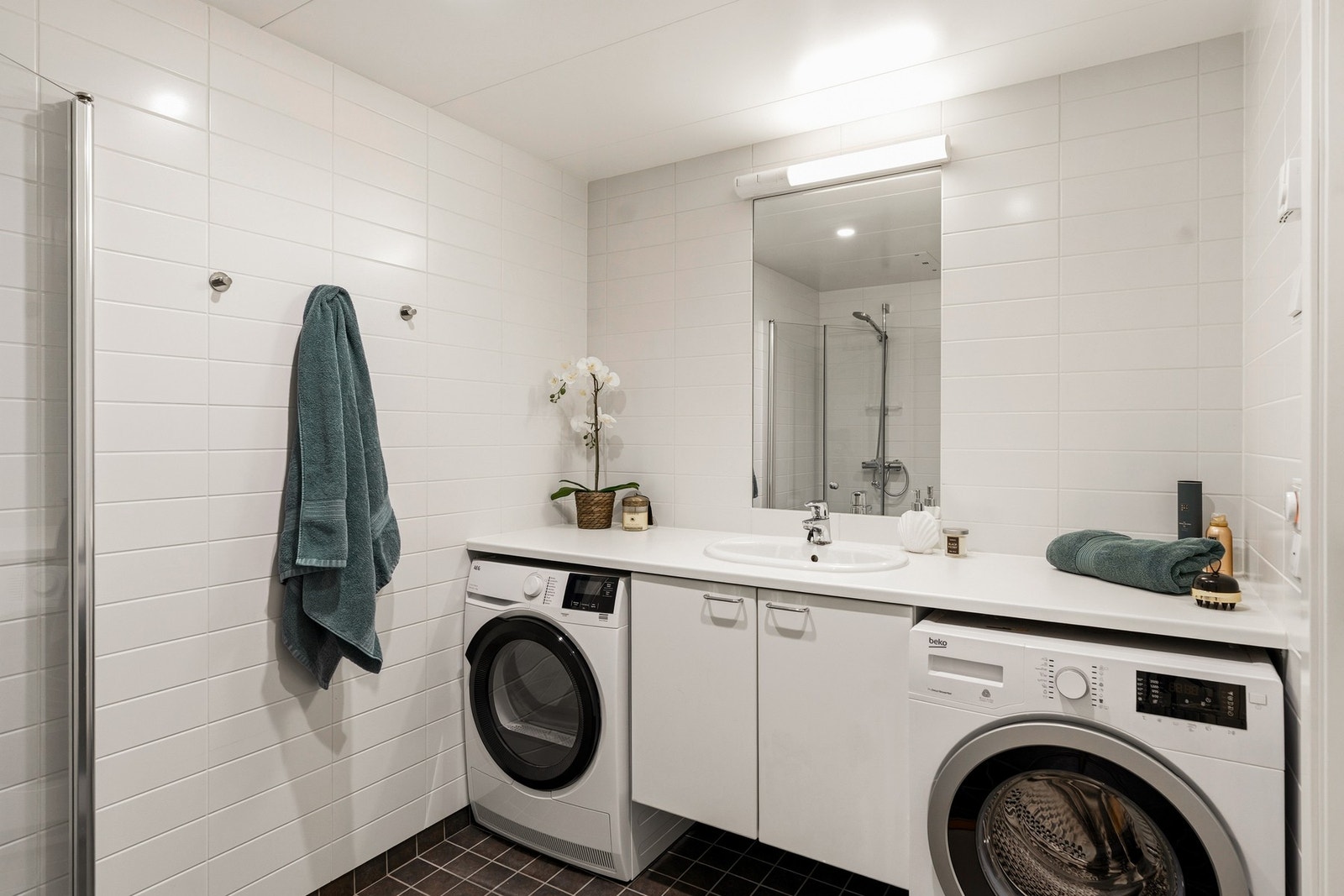 Badet er innredet med glatte fronter, servant, klosett og dusjhjørne. Galleribilde