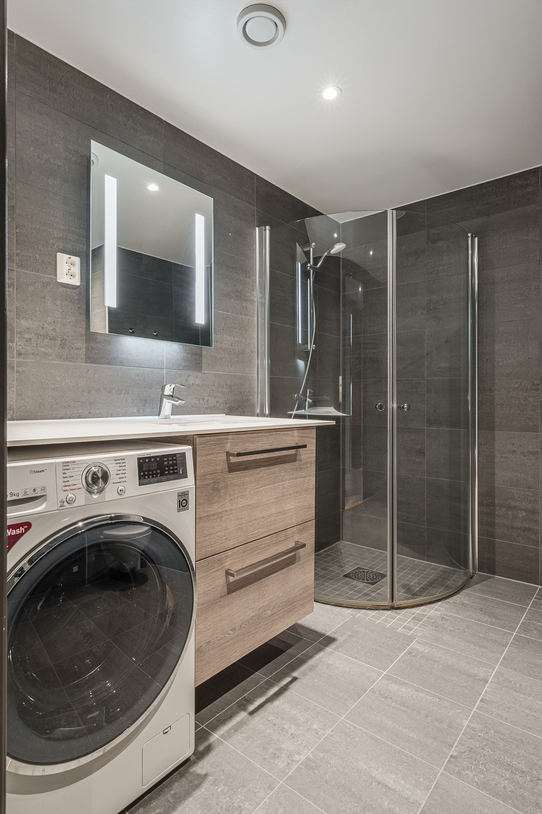Det andre badet har dusjhjørne med glassvegger og praktisk opplegg for vaskemaskin. Galleribilde