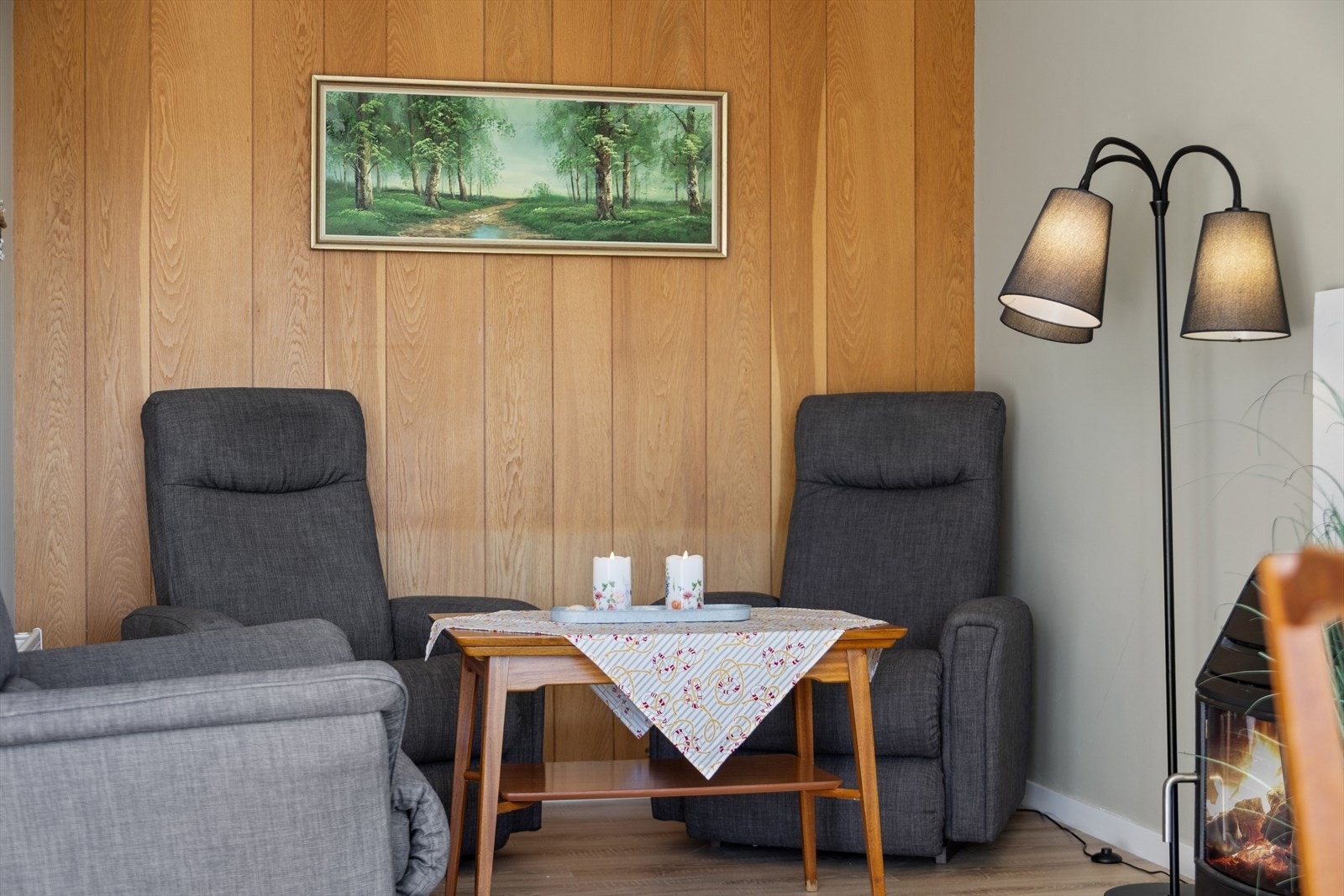 En hyggelig krok i stuen for avslapning. Veggene har en kombinasjon av slette, malte flater og panel. Galleribilde
