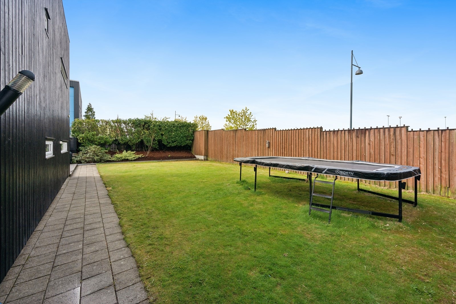 Tilnærmet flat og stor hage. Her har man god plass til trampoline og hagen egner seg ellers ypperlig som fotballbane for de yngste i familien. Galleribilde