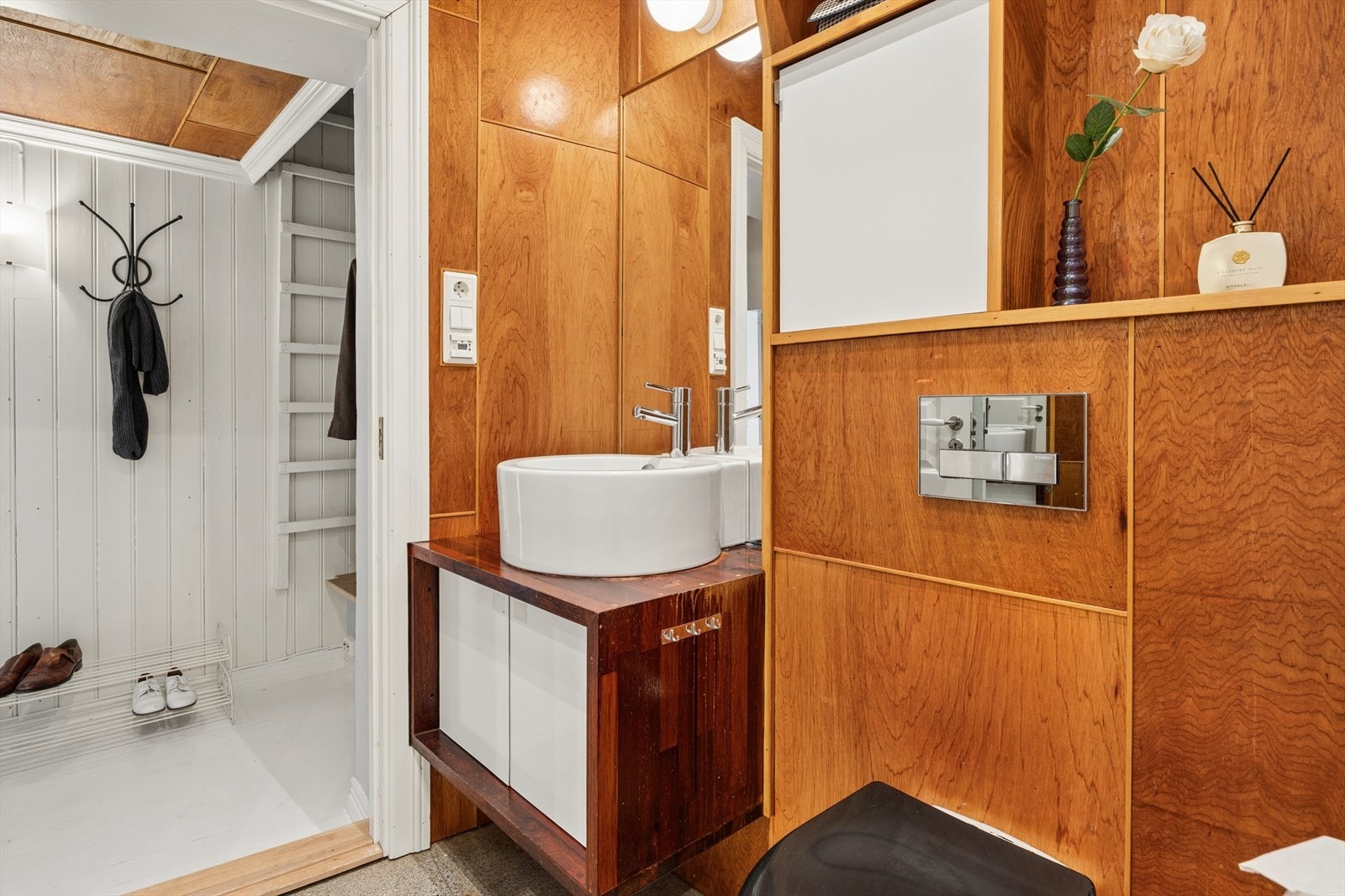 Det stilfulle badet består av en blanding av hvite fliser og lakkerte marantiplater. Galleribilde