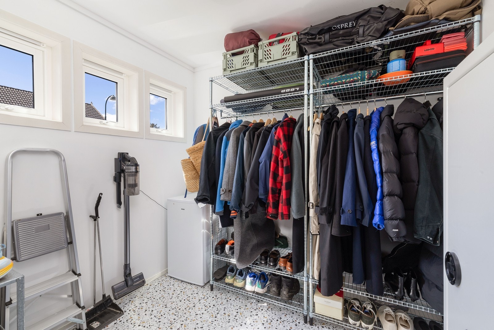 Stor bod/walk in garderobe innredet med garderobeskap og god plass til oppheng av yttertøy og sko. Galleribilde