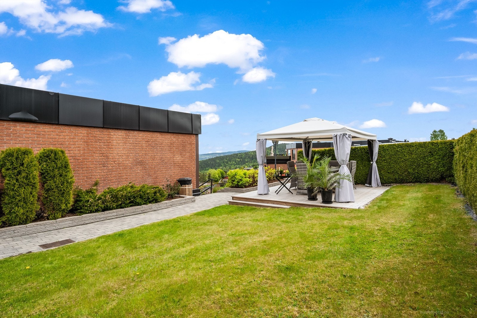 Fellesarealet er pent opparbeidet med nydelige beplantninger og platting med pergola. Galleribilde
