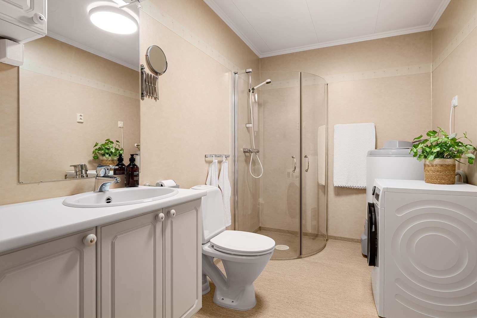 Badet er på ca. 6 kvm. og er utstyrt med servant, wc, dusjhjørne og opplegg for vaskemaskin Galleribilde