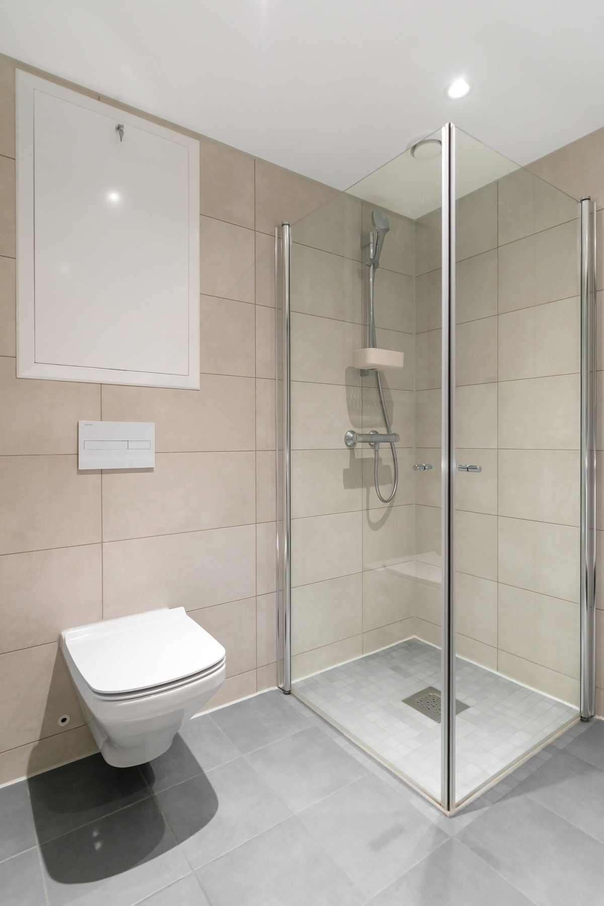 Badet er innredet med moderne baderomsinnredning med glatte fronter, og er utstyrt med servant, vegghengt klosett, dusjløsning samt praktisk opplegg for vaskemaskin. Vaskemaskinen medfølger handelen Galleribilde