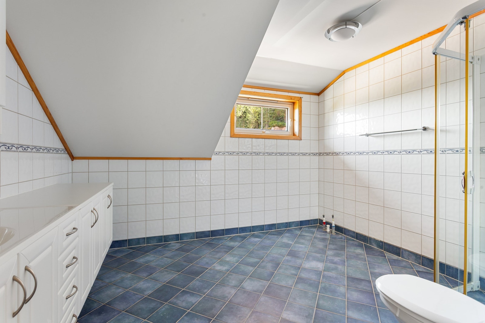 Badet har skråtak og et vindu som gir godt med dagslys. Galleribilde