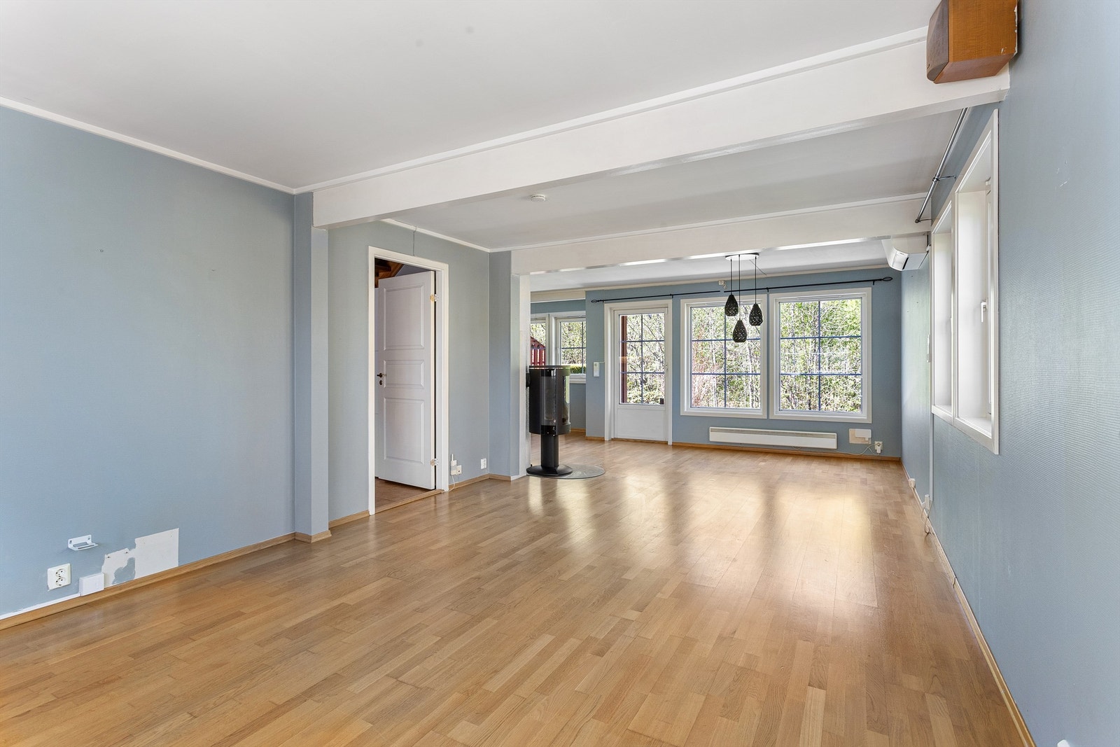 Stue og kjøkken i en åpen løsning gir en sosial samt luftig atmosfære, med gjennomgående parkett på gulvet. Galleribilde