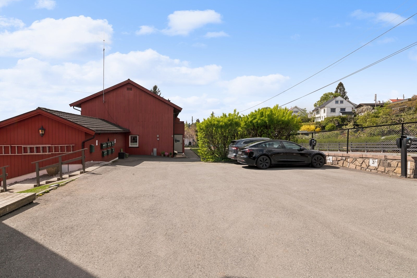 Sameiets tomt er pent opparbeidet med asfaltert parkeringsområde og hageanlegg med plen og beplantninger. Galleribilde