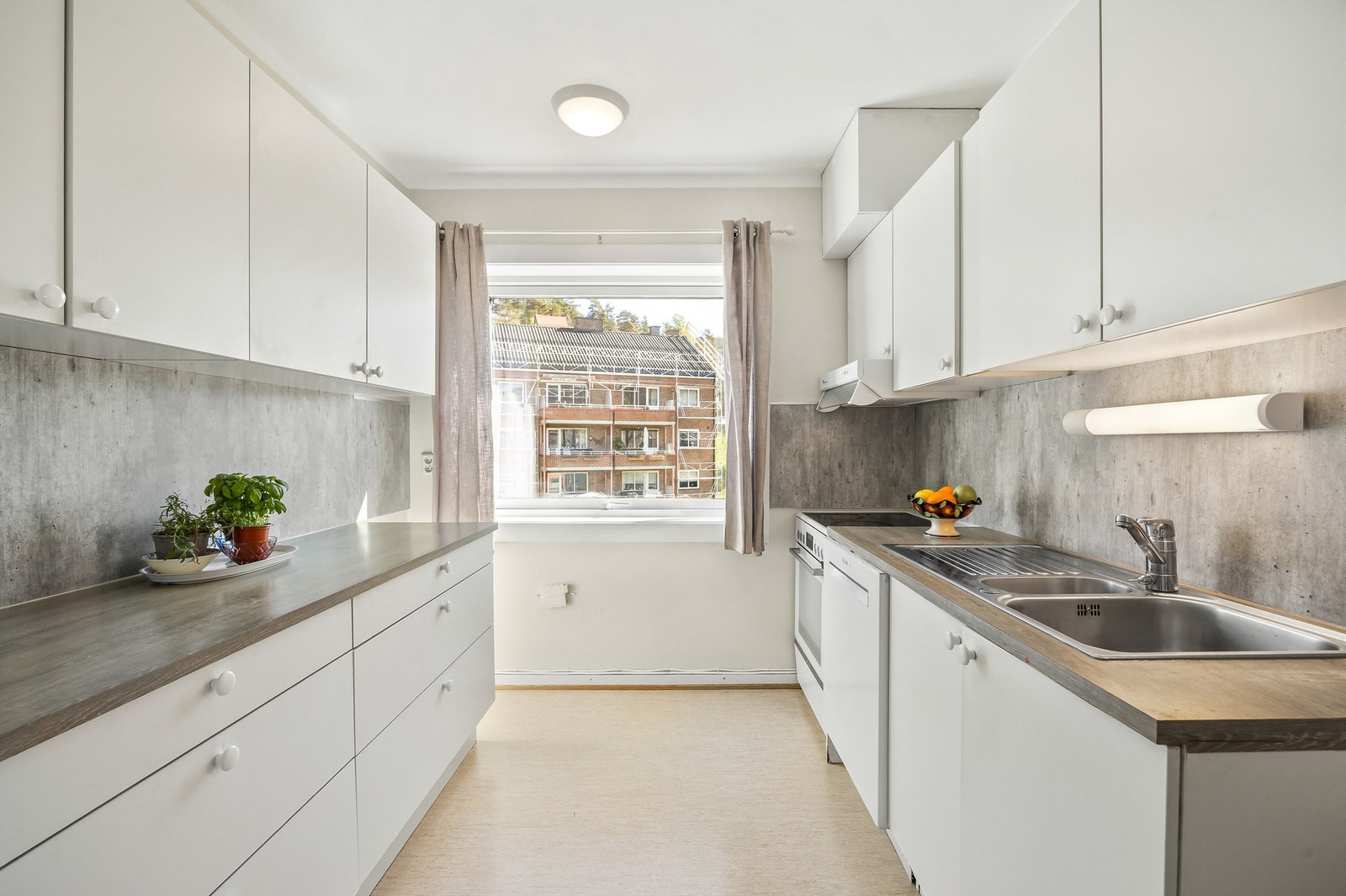 Kjøkken med innredning med glatte fronter. Benkeplate med laminert overflate og nedfelt kjøkkenvask. Galleribilde
