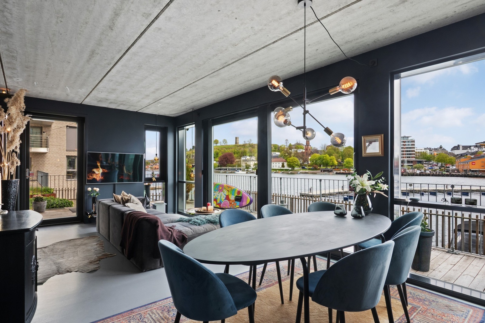 Stuen ligger i åpen løsning med kjøkkenet, og sammen danner de et innbydende og spennende allrom med unike detaljer, rå industristil og magisk utsikt via store vindusflater. Galleribilde