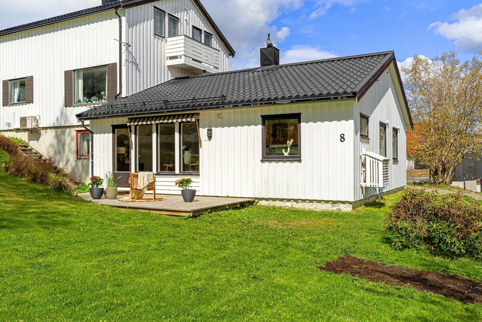 Solrikt uteområde med terrasse og pent opparbeidet hage. Galleribilde