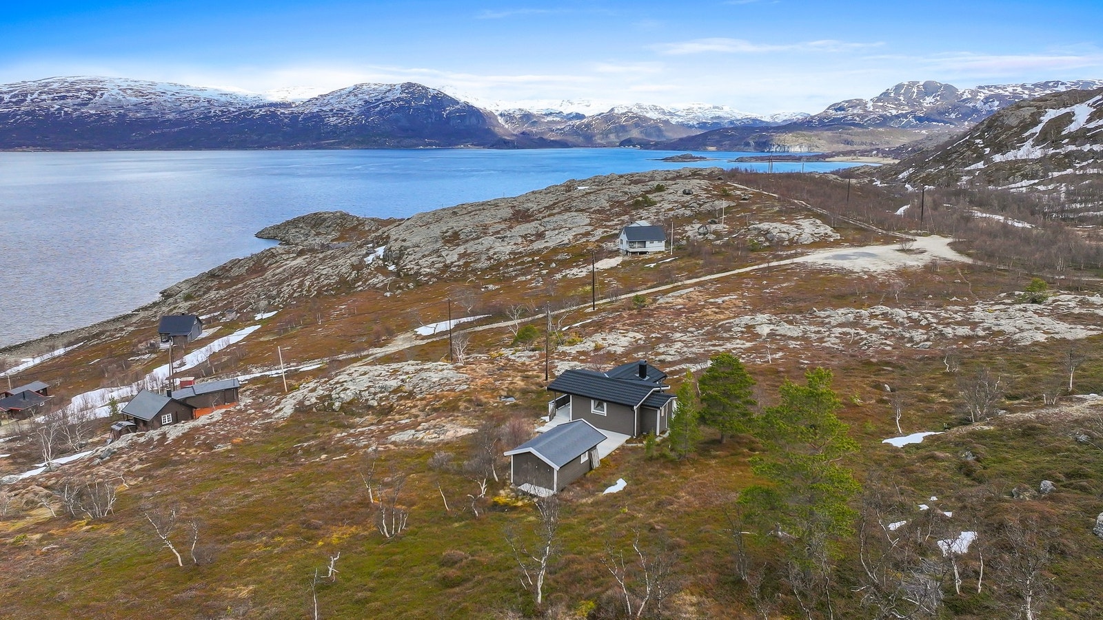 Oversiktsbilde som viser hyttas plassering i det storslåtte landskapet. Galleribilde