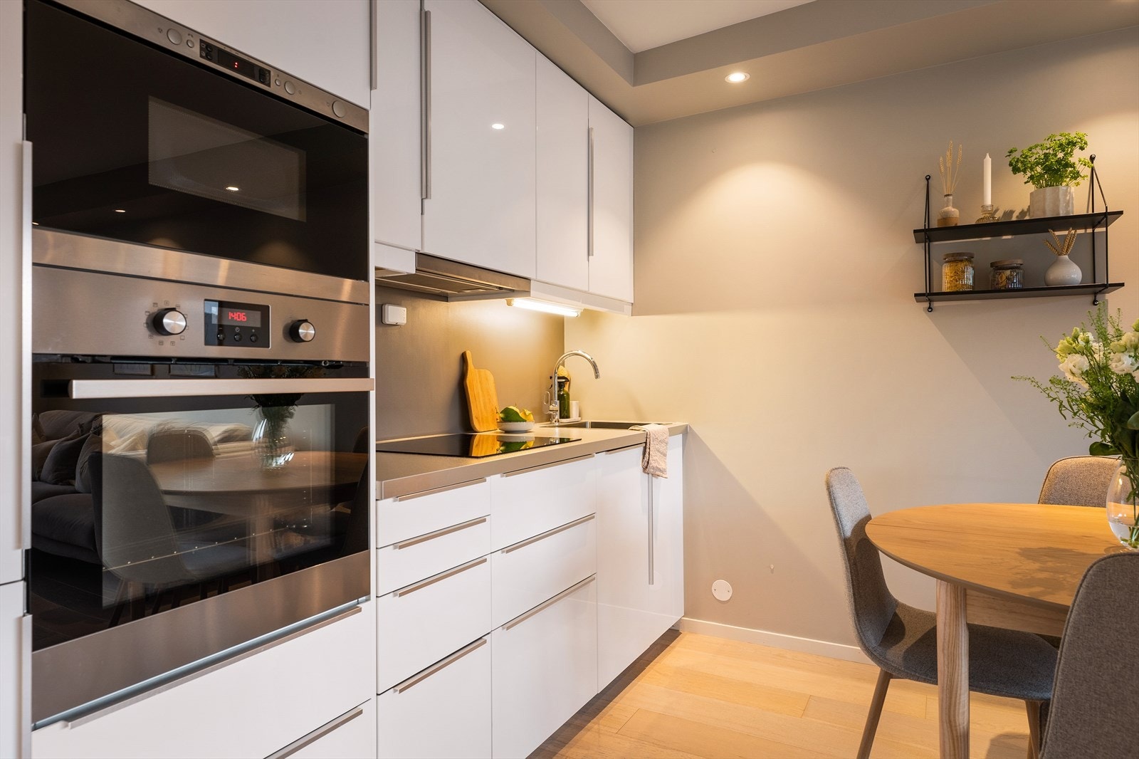 Kjøkkenet fremstår moderne og stilrent med hvite slette fronter og laminat benkeplate. Galleribilde