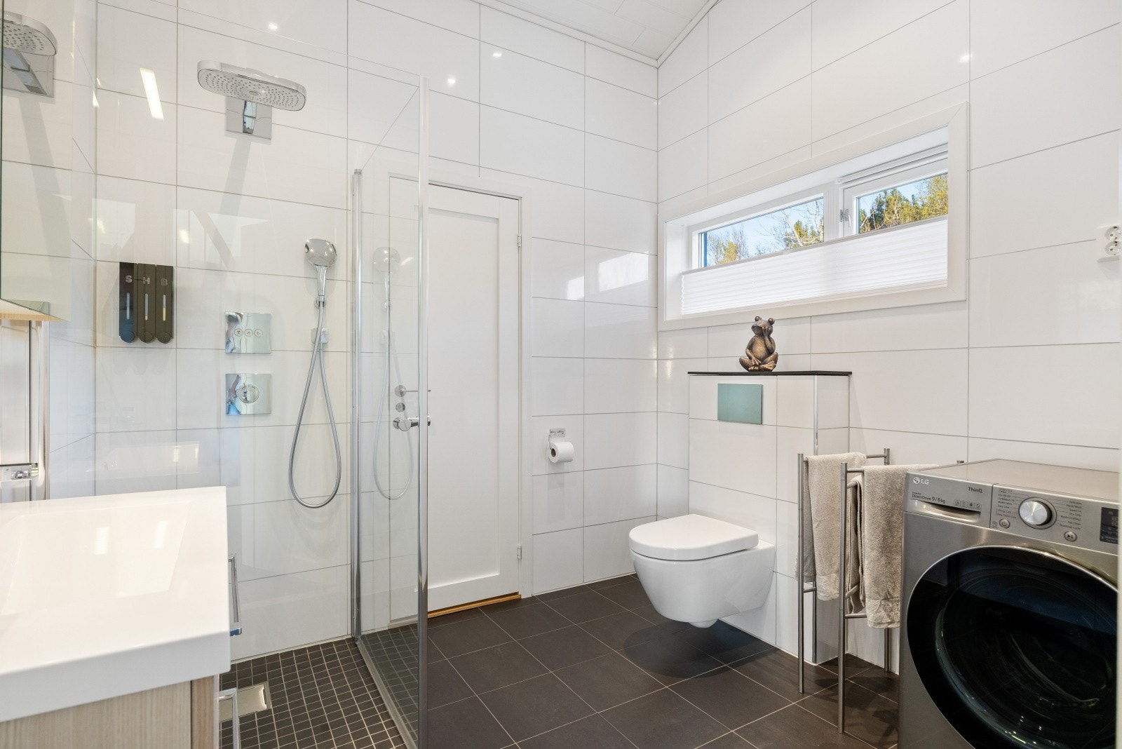 Dette badet er kombinert vaskerom med opplegg for vaskemaskin. Galleribilde