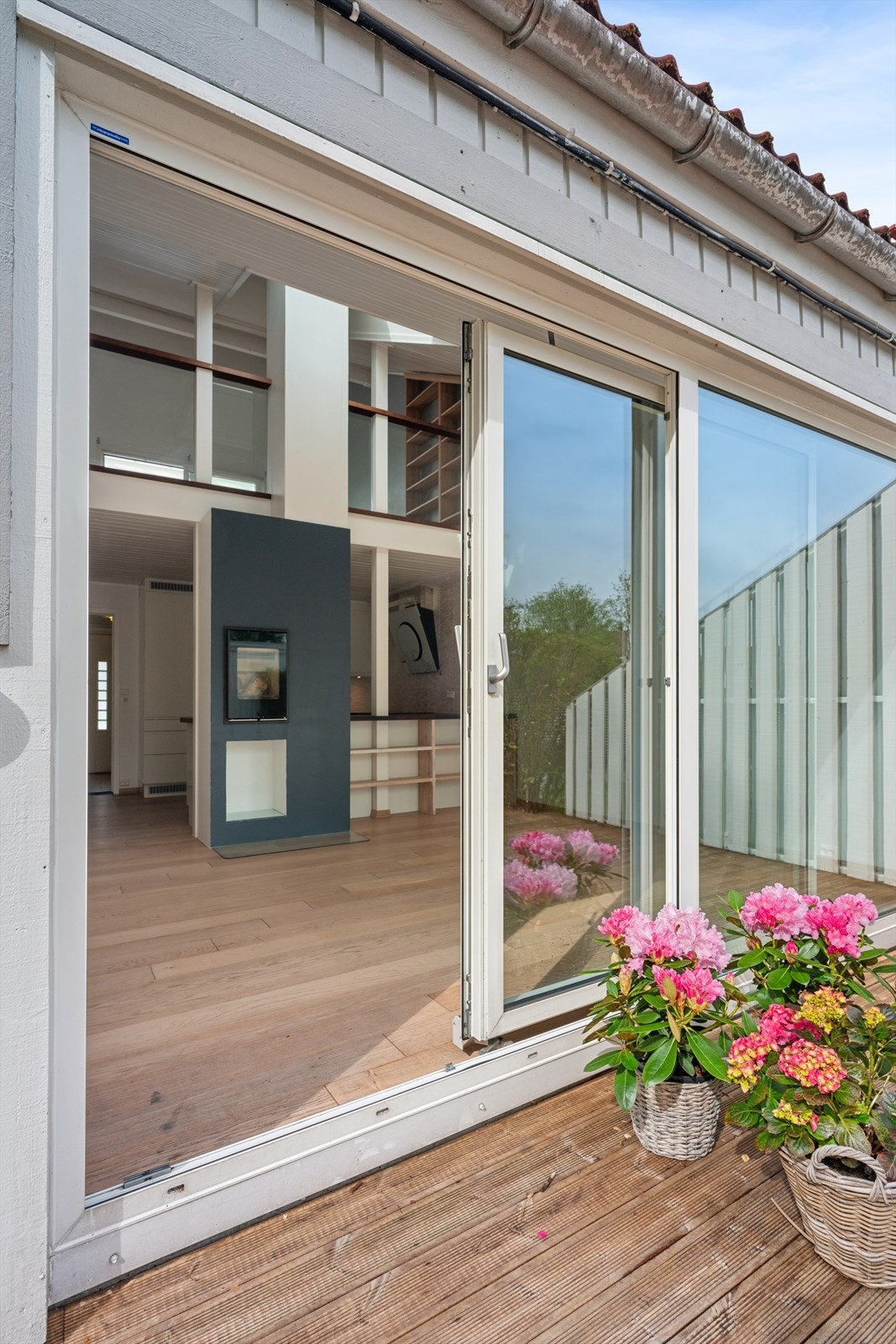 Skyvedøren i aluminium og glass visker ut skillet mellom stuen og terrassen. Galleribilde