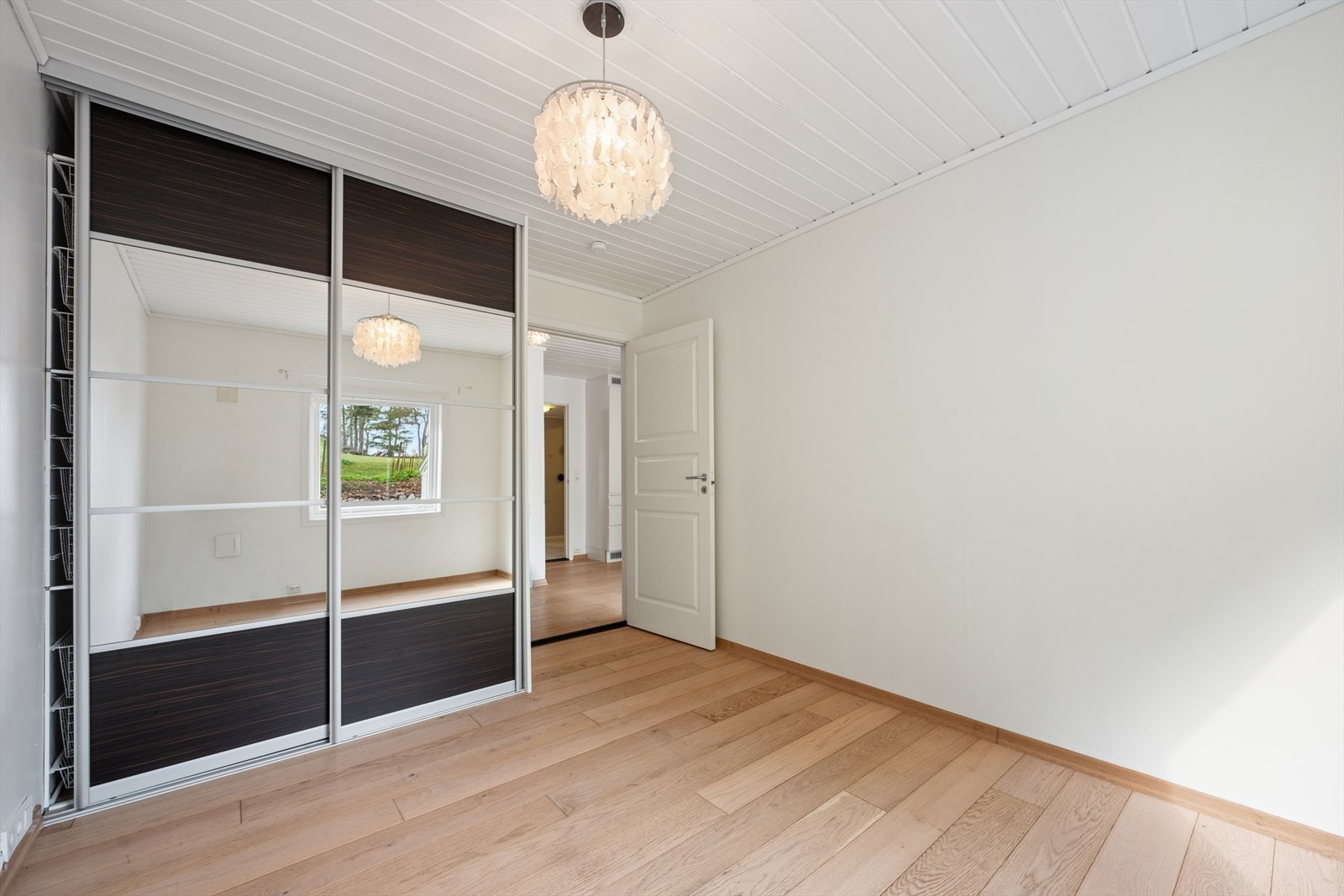 Soverom i første etasje med en romslig skyvedørsgarderobe med speilfronter. Galleribilde