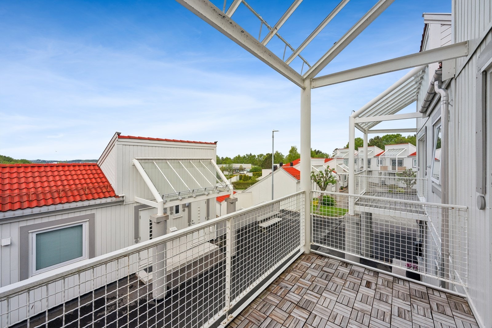 Balkongen har terrasseflis på dekket og rekkverk i stål. Galleribilde
