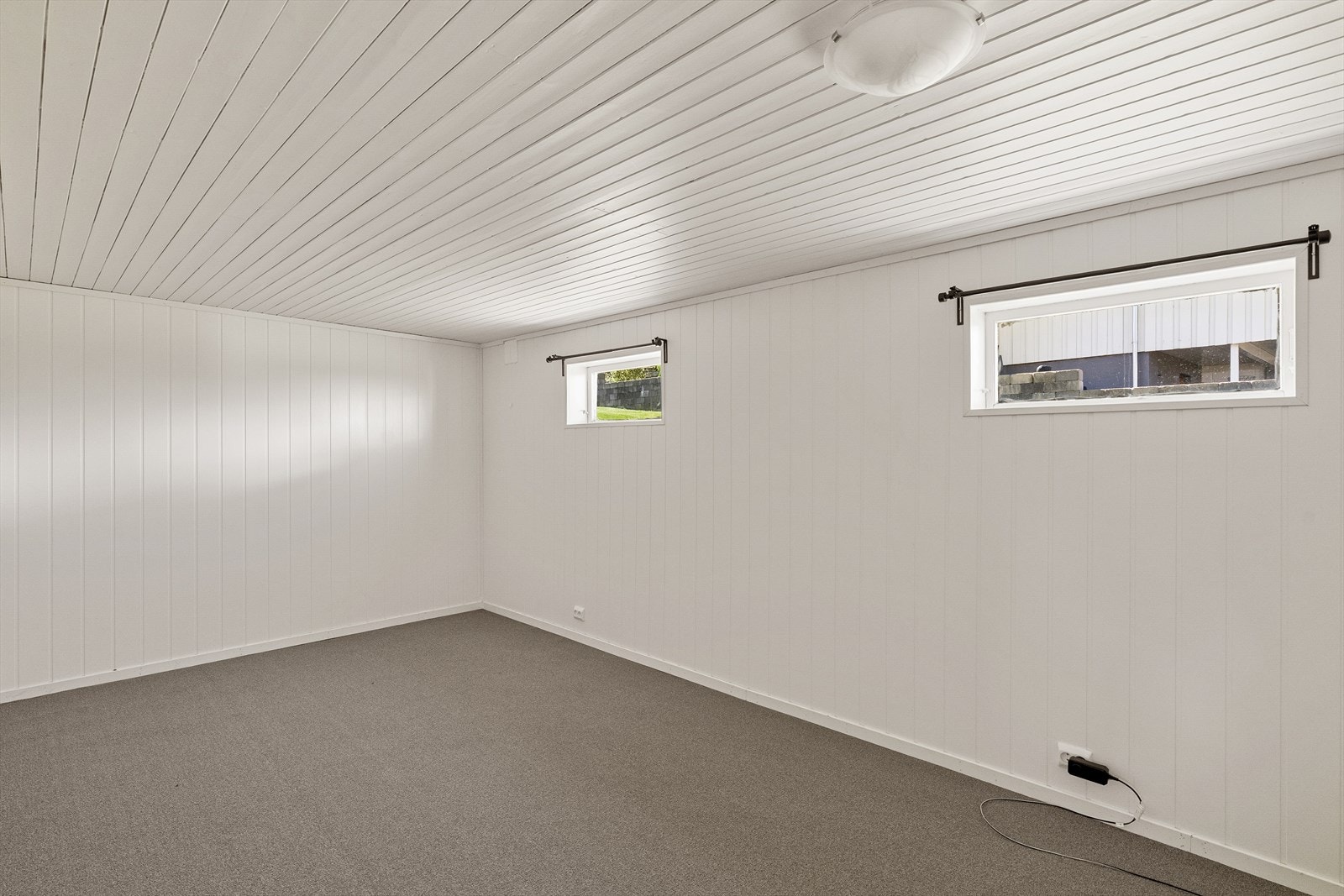 Kjellerstuen har teppe på gulvet og panelplater på veggene. Galleribilde