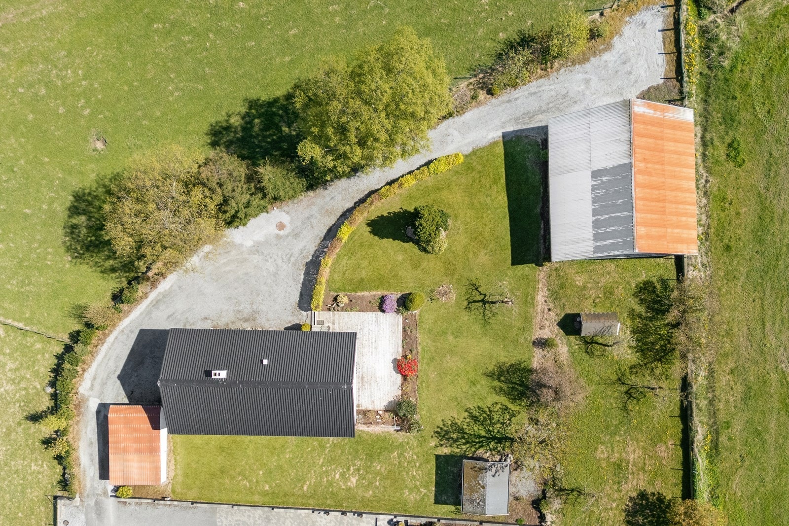 Tomten sett fra luften, som viser boligens plassering, uteområder og de tilhørende bygningene. Galleribilde