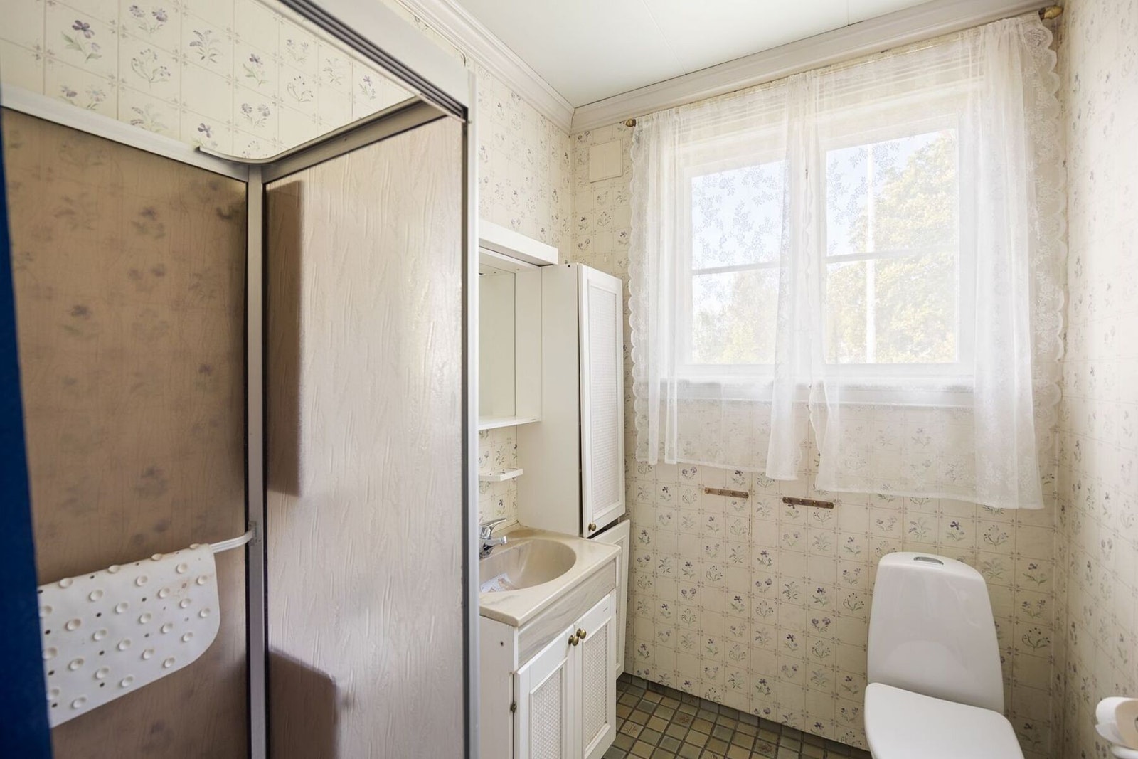 Badet er innredet med dusjkabinett, servant i innredning og toalett. Galleribilde