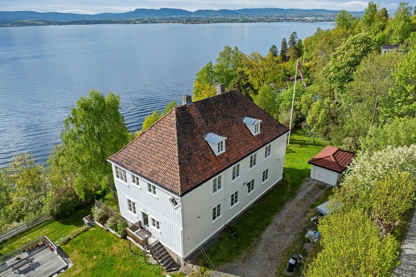 Eiendommen har hyggelige uteområder med terrasse og adkomst videre til hagen og terrenget rundt boligen Galleribilde