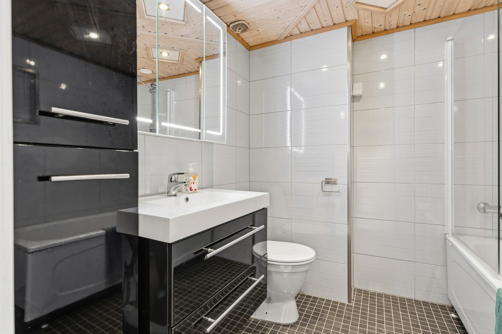 Det romslige badet har flislagte vegger og gulv med gulvvarme Galleribilde