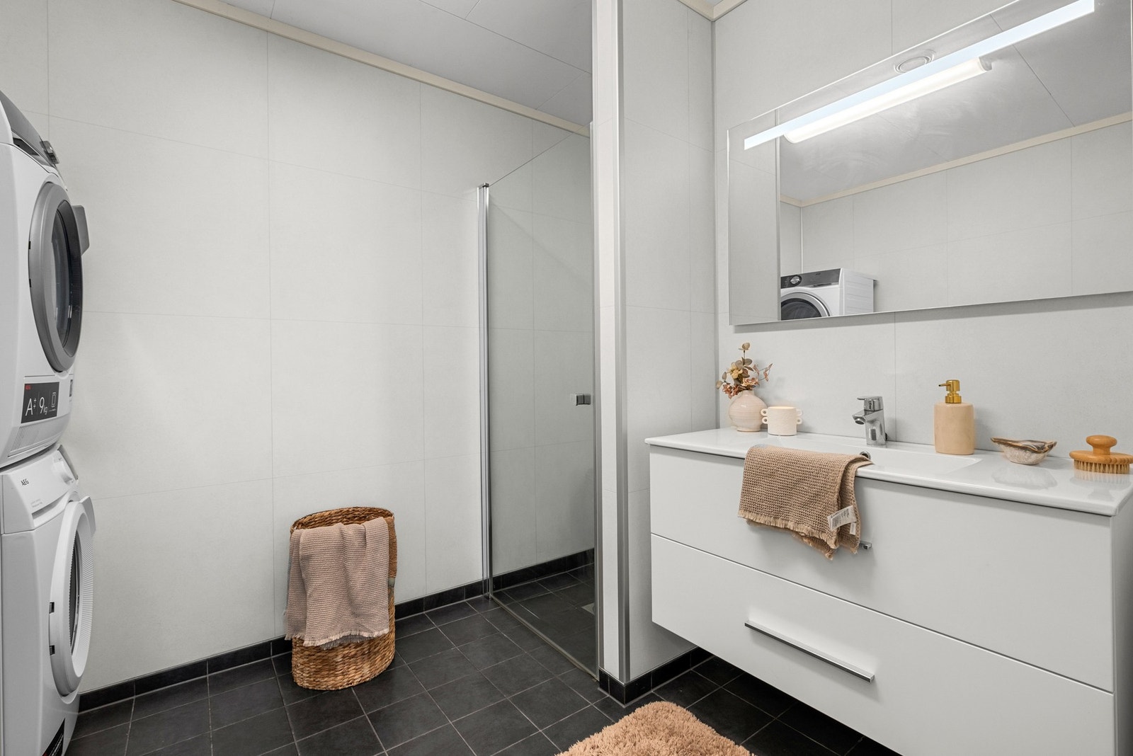 Bad/vaskerommet er utstyrt med dusjplass med glassdør, toalett og opplegg for vaskemaskin. Galleribilde
