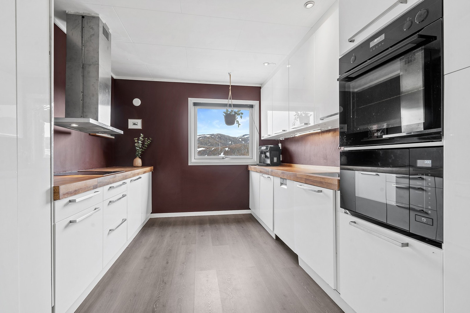Kjøkkeninnredning med glatte fronter, laminatbenkeplate og integrert stekeovn og micro fra 2022. Galleribilde