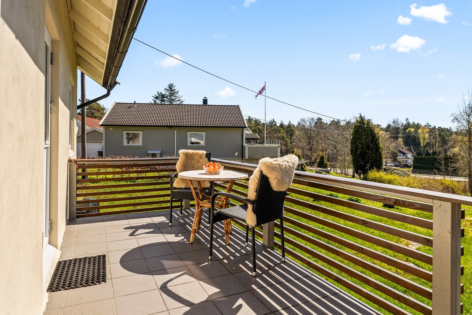Stor terrasse med utgang til en romslig og solrik gressplen - perfekt for hyggelige sommerdager. Galleribilde