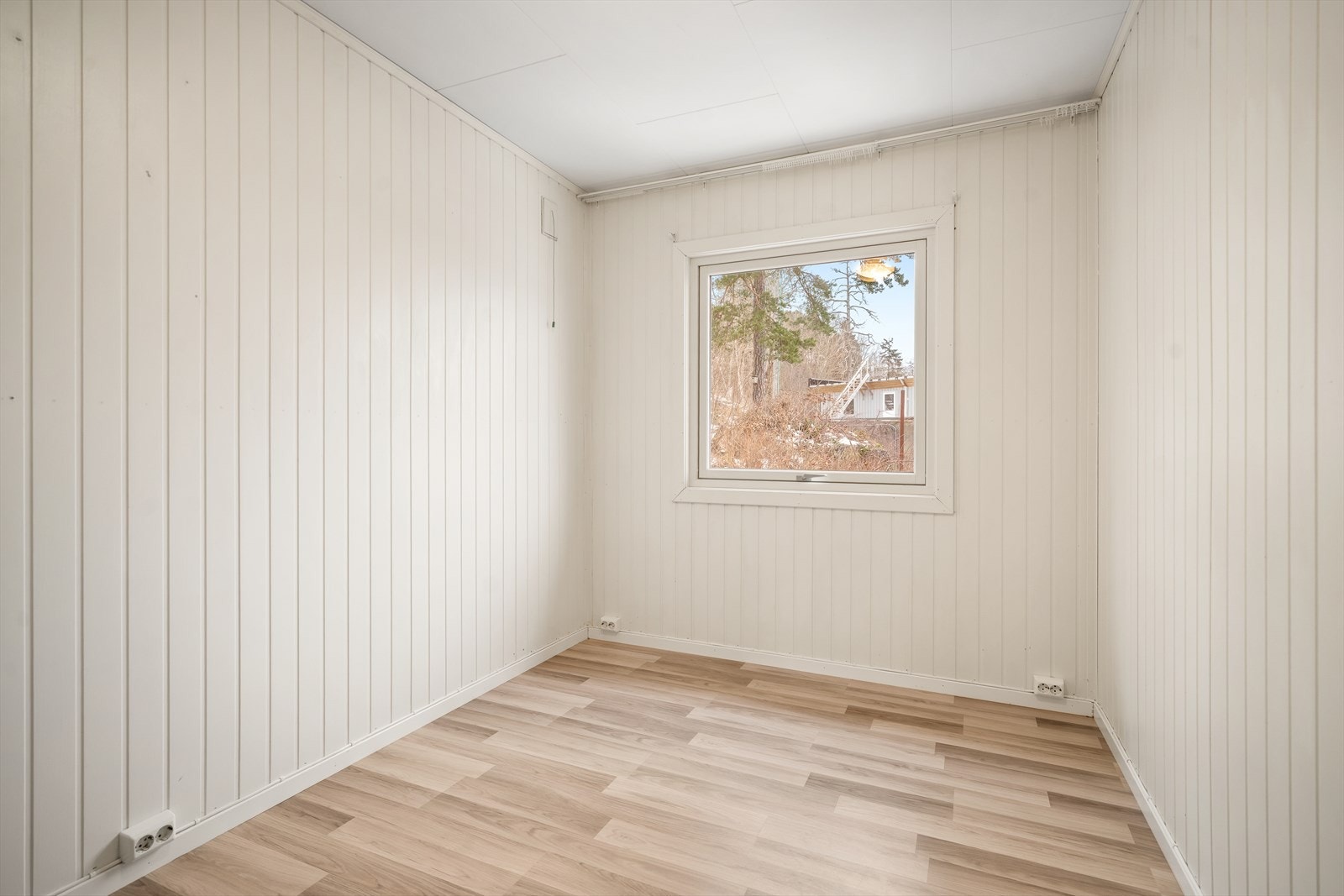 Lyst og pent soverom med stort vindu i tilbygg Galleribilde