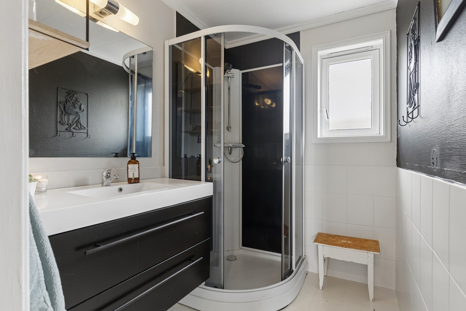 Badet er utstyrt med dusjkabinett, servant i innredning og elektriske varmekabler i gulvet. Galleribilde