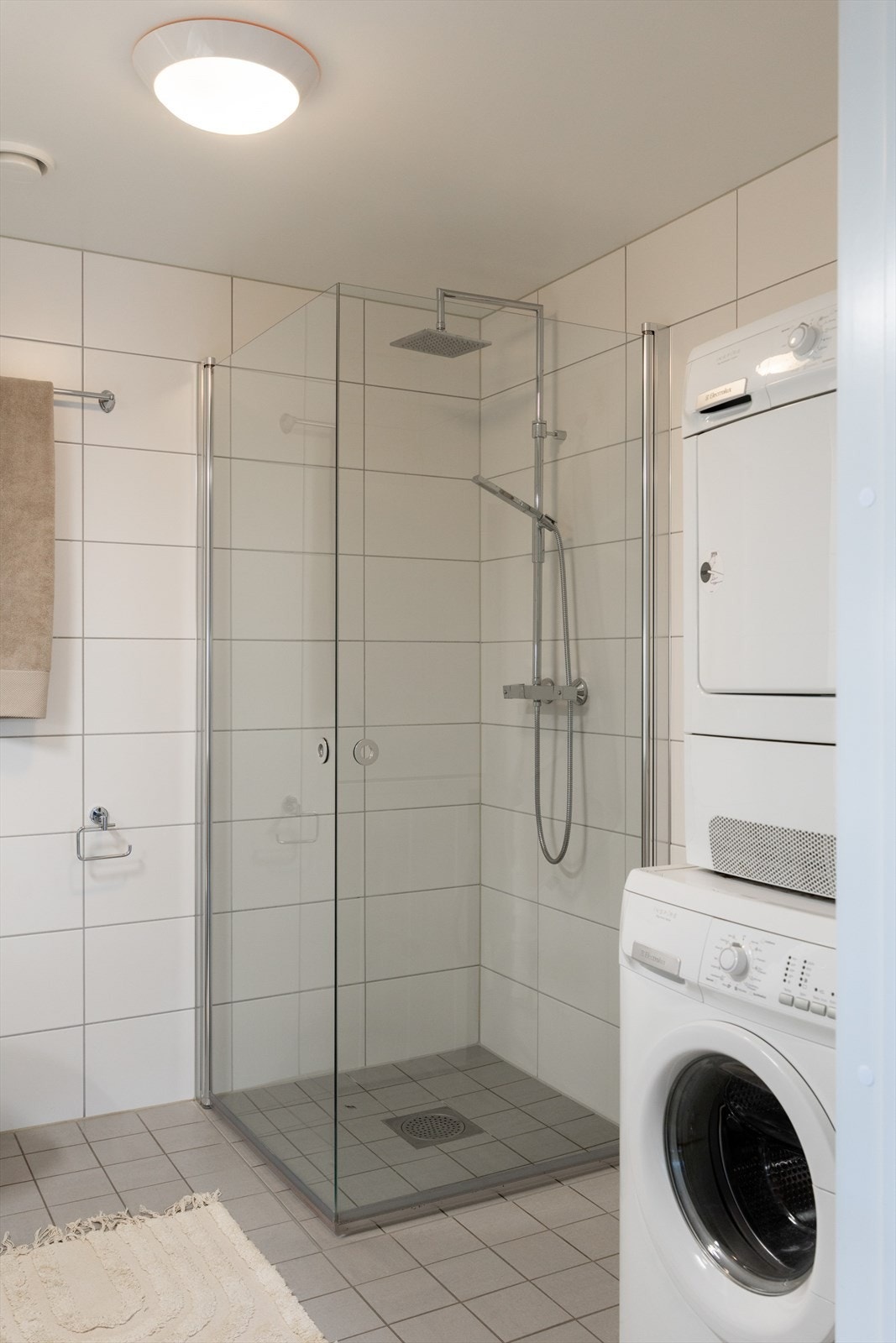 Badet er innredet med vegghengt klosett, servant nedfelt i innredning, speilskap m/lys og dusjhjørne med svingbare glassdører. Galleribilde