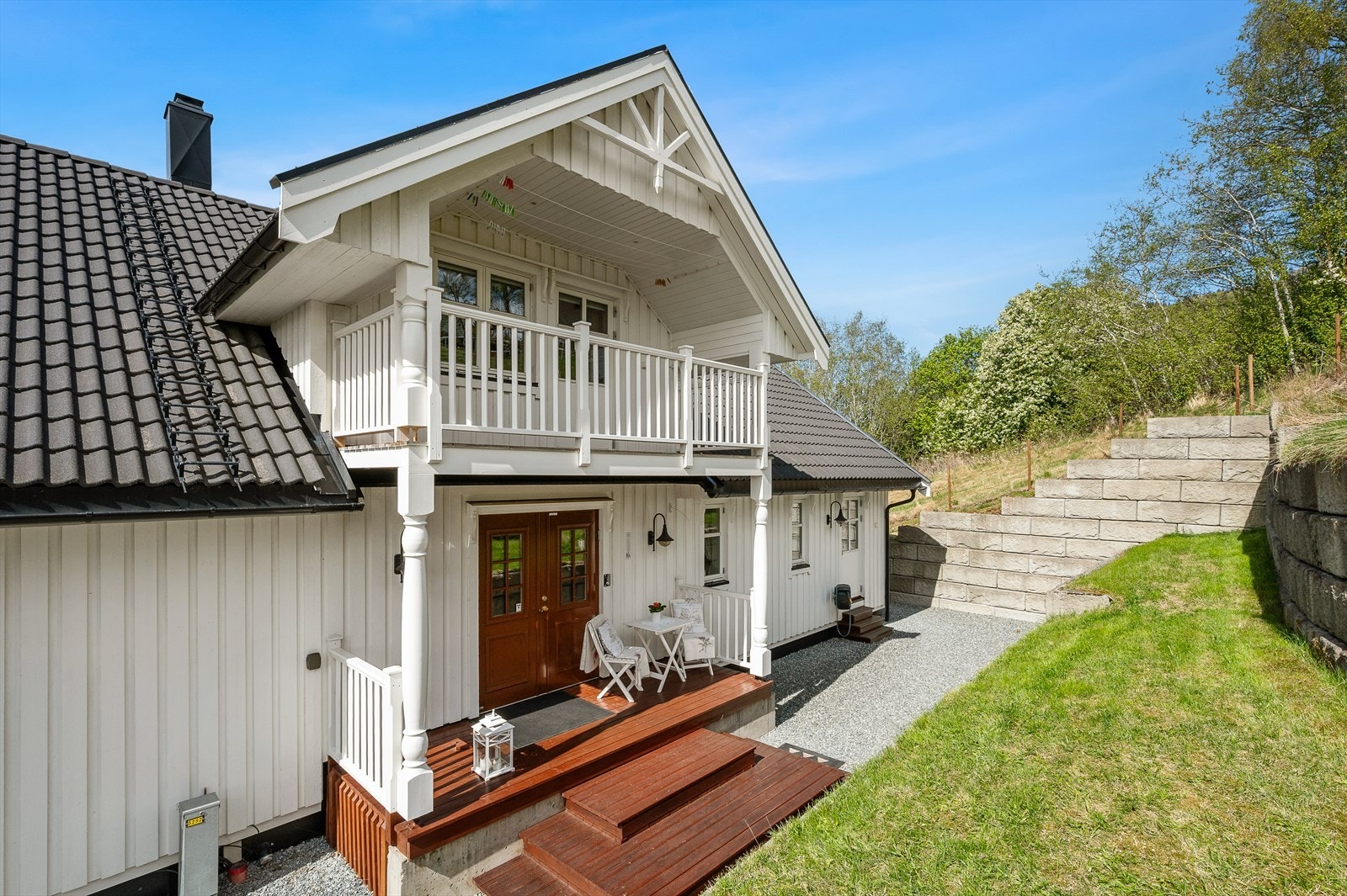 Eiendommen byr på en attraktiv kombinasjon av en romslig bolig, utleiedel, stor garasje og egen carport. Her med et flott og praktisk inngangsparti med overbygd balkong. Galleribilde