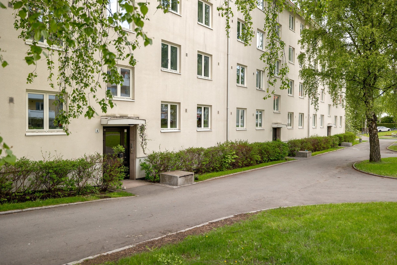 Adkomst via bilfri stikkvei og frodige grøntareal med god avstand mellom blokkene. Galleribilde